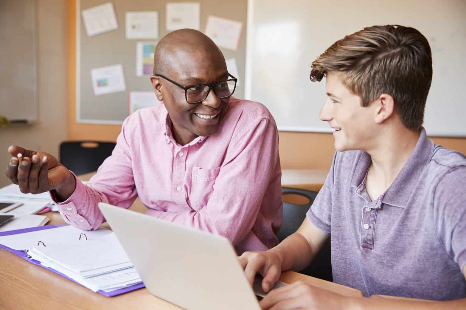 High School Teacher Giving Male Student One To One Teaching Personalized learning